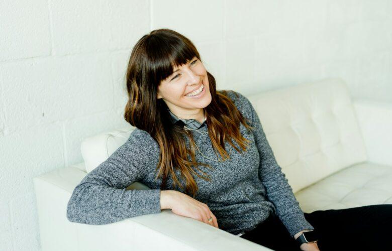 woman in gray sweater sitting on white chair